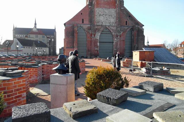 Vom südöstlichen Sockelmauerwerk des ehemaligen Kirchenschiffs bietet sich der Blick auf den Marienkirchturm, im Hintergrund links die Georgenkirche.