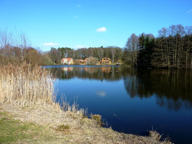 Blick auf Wohnhäuser und die sich spiegelnde Landschaft