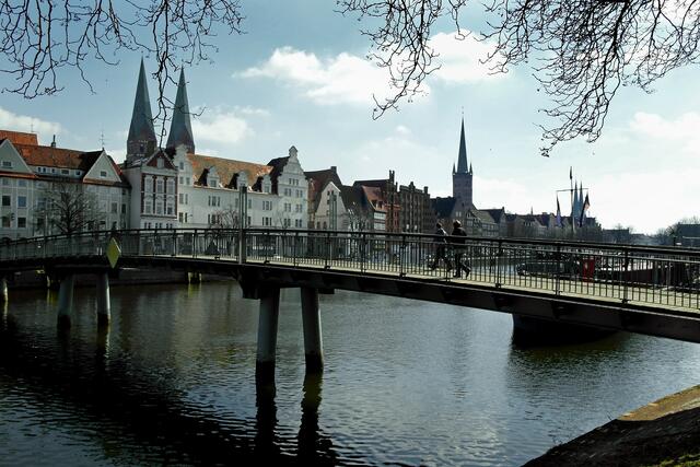 Der Blick von der Musik- und Kongresshalle über die Stadttrave zur Altstadtinsel mit den beiden Türmen von St. Marien und dem von St. Petri