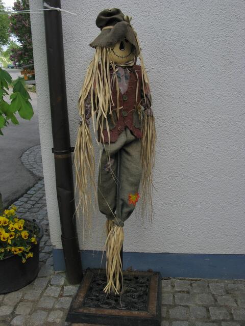 Strohmännchen vor dem Hofladen.
