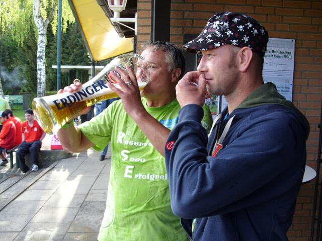 Trainer Alf Miener nimmt den verdienten Meisterschluck - Holger Kaiser wartet auf den Bierpokal
