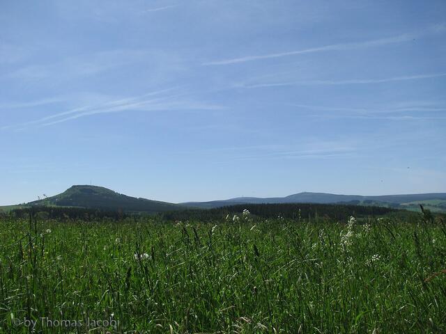 Blick über weite Wiesen zum Bärenstein, Keilberg und Fichtelberg.