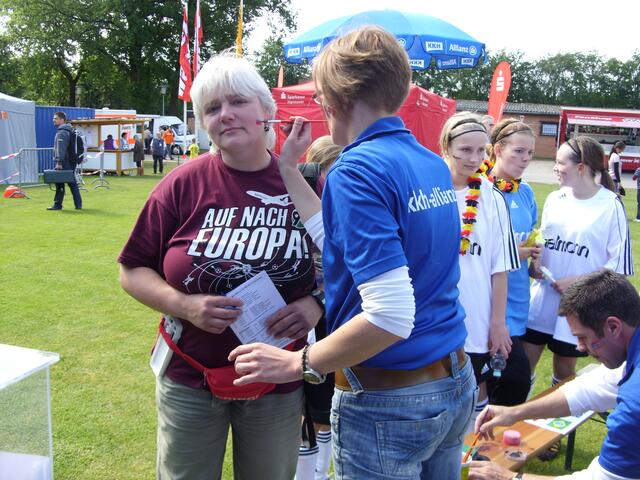 Die Fans lassen sich die Nationalflaggen auf die Wangen schminken.