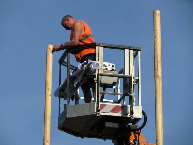Zum Befestigen der Fahne müssen erst Schrauben in den Mast gedreht werden.