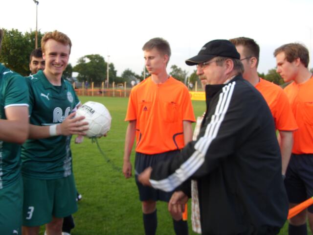 Staffelleiter Manfred Schütte überreicht Spielführer Tjark Miener den Meisterball