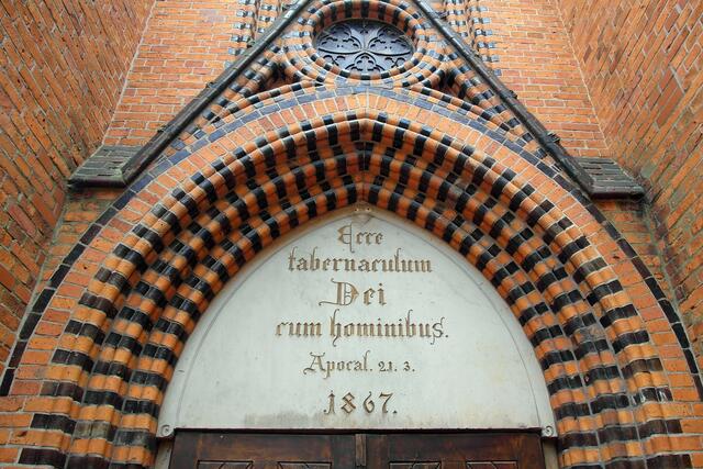 Über dem Portal der Peiner Kirche steht die Inschrift "Ecce tabernaculum Dei cum hominibus" (Seht, das Zelt Gottes bei den Menschen).