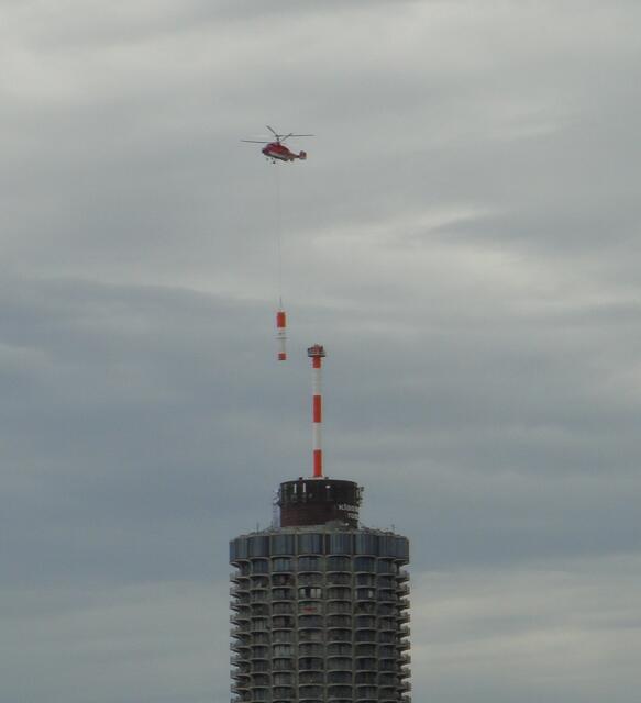 Das 5. und letzte Teil des Antennenmastes fliegt heran. Dieses Mal hat es nicht beim 1. Anflug geklappt, der Hubschrauber brauchte einen 2. Anlauf.