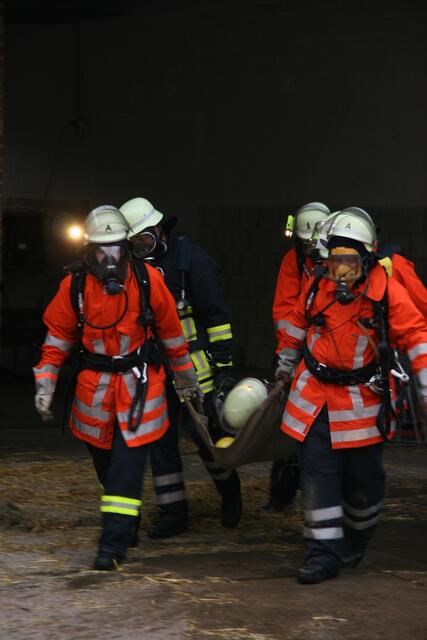 Ein verletzter Feuerwehrmann wird von den Rettungstrupps aus dem Gebäude transportiert