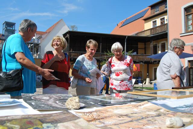 Gäste nehmen die Werke von Brigitte Plischke in Augenschein.