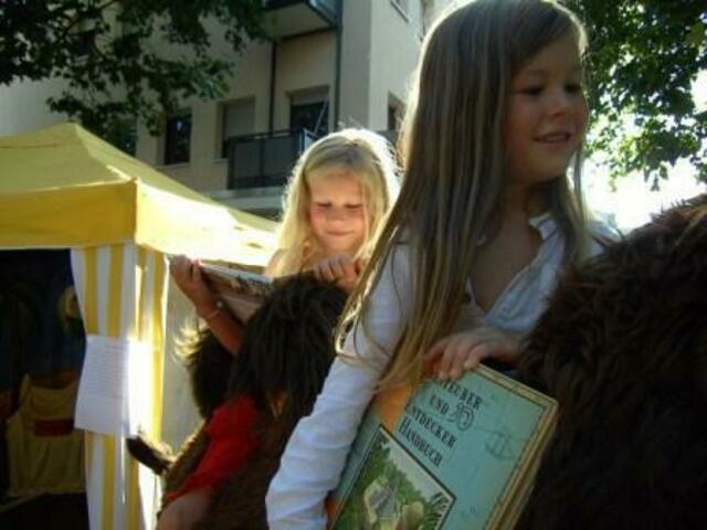 Wüstenprinzen und Prinzessinnen reiten in der Lauterborner Abendsonne mit einem Kinderbuch in das Land der Phantasie.