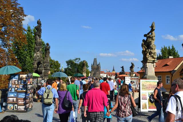 Auf der Karlsbrücke werden Souveniers angeboten, junge Leute singen und spielen. Im Sommer ist noch bis in den tiefen Abend hinein viel los.
