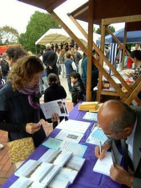 Fest der Kulturen in Mühlheim am Main _ Vom Stand des Offenbacher Autor Mehmet Ali Zaimoglu aus gesehen; hier beim Signieren seiner Lebenserinnerungen.
