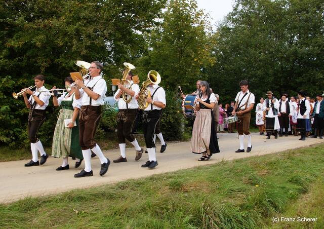 Bayerisch-ungarischer Oxentag. Angeführt von den Gail-Buam-Musikanten geht es den Römerweg hinauf zur Adelzhausener Mehrzweckhalle