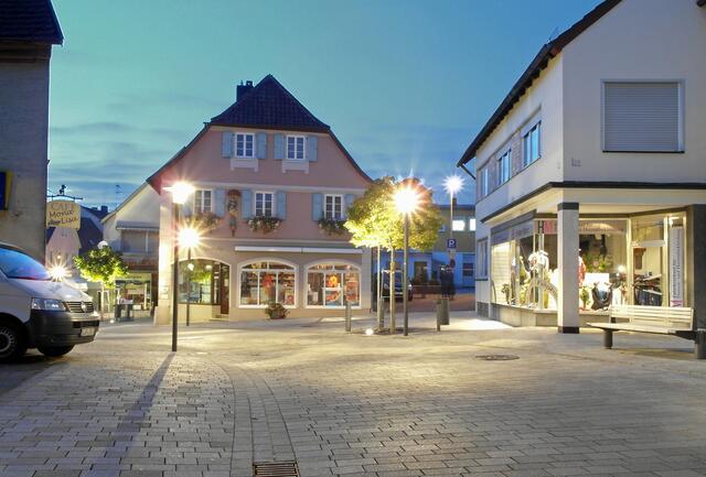 Das Licht der Straßenlaternen hat sich mittlerweile durchgesetzt und hebt die Marienapotheke deutlicher hervor.