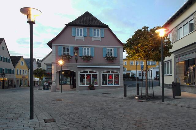 Noch steht das Abendlicht in Konkurrenz zu den Straßenlaternen, so dass die Marienapotheke in der Bahnhofstraße noch nicht so richtig zur Geltung kommt.