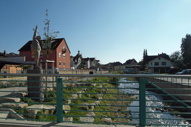 Als Blickfang steht eine Holzskulptur neben der neuen Brücke.