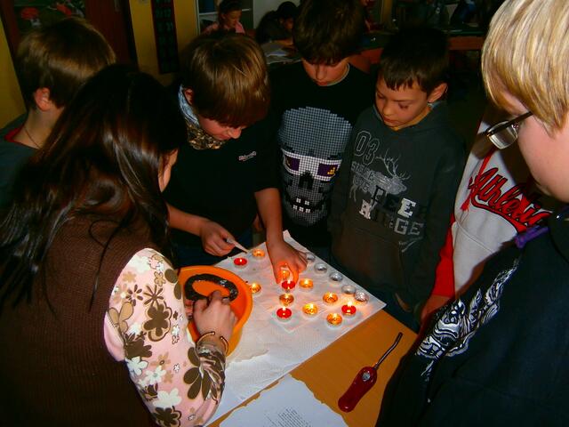 Das flüssige Wachs muss durch die Öffnung des silbernen Schlüssels gegossen werden.