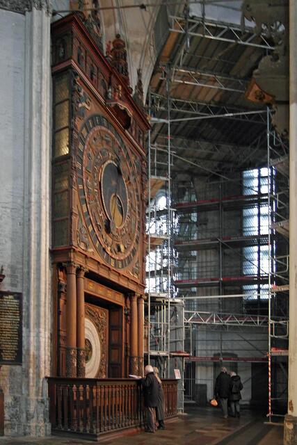 Düringer hatte eine ähnliche Uhr in der Danziger Marienkirche fertiggestellt. Um in Rostock Kosten zu sparen, verwendete er Teile der Vorgängeruhr, die 1379 von einem Meister aus Lübeck erbaut und bei den Bauarbeiten zur Erweiterung der Kirche erheblich beschädigt worden war. Oberer Teil: Hauptuhrwerk, unterer Teil: Kalenderwerk.