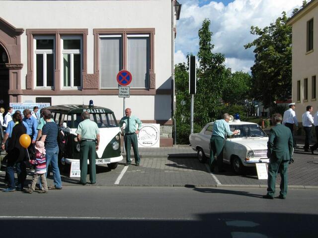Polizisten in historischer Uniform bei historischen Fahrzeugen