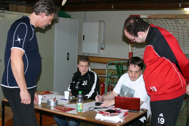 Turnierleiter Lars Klingenberg beim Abgleich der Ergebnisse, im Vordergrund Schiedsrichter Rolf Tameling und Trainer Stefan Hinterthür (SF Aligse)