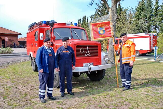 Der Magirus (Baujahr 1959) und davor Ralf Boeck, Wilfried Wiedenroth, Hans-Hermann Brockmann (v.li.) mit der Feuerwehrfahne.