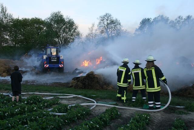 Löscharbeiten an dem verteilten Brandgut