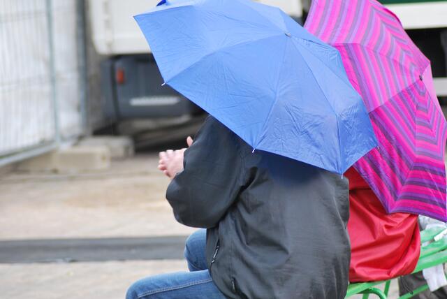 Klatschen unterm Regenschirm.
