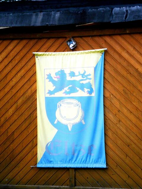 Das Wappen von Eltze schon leicht ausgebleicht: Im geteilten Schild oben in Gold ein  blauer Löwe, unten in Blau ein goldener Grapen.