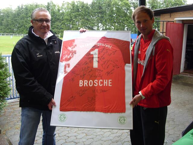 Alf Miener (links) Trainer der Reserve des RSE überrascht Benny Brosche mit einem Trikot mit den Unterschriften seiner Mitspieler.