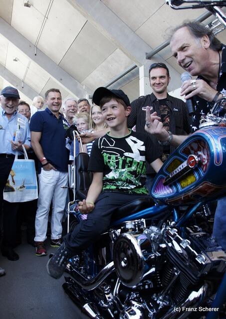 1. Augsburger Porsche Freundschaftstreffen - Schauspieler Wolfgang Fierek freut sich über sein neues Harley Davidson Custom-Bike vom Harley Davidson Westpoint Augsburg - Für den jungen Fan gabs gleich noch eine Anleitung fürs richtige Bikerverhalten