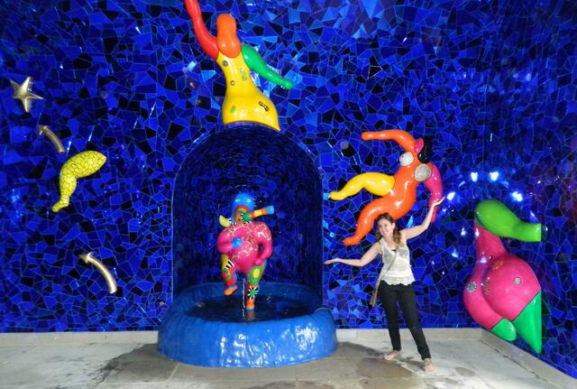 Niki de Saint Phalle Grotte - blauer Saal mit Wandreliefs der Tanzenden Frauen und Brunnen mit Figur der elefantenköpfigen Gottheit Ganesha