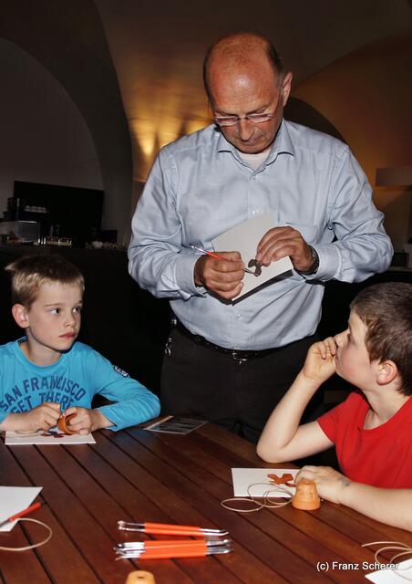 Botschaft an die Zukunft. Kinderprogramm zur Sonderausstellung "Ausgegraben - Archäologie am Friedberger Lechrain" im Museum im Friedberger Wittelbacher Schloss - Nach der Ausstellung sollen Botschaften an die Zukunft entstehen. Am Ende wird noch ein Schmuckstück gefertigt. Museumskustos Hans Beil zeigt, wie 's gemacht wird.