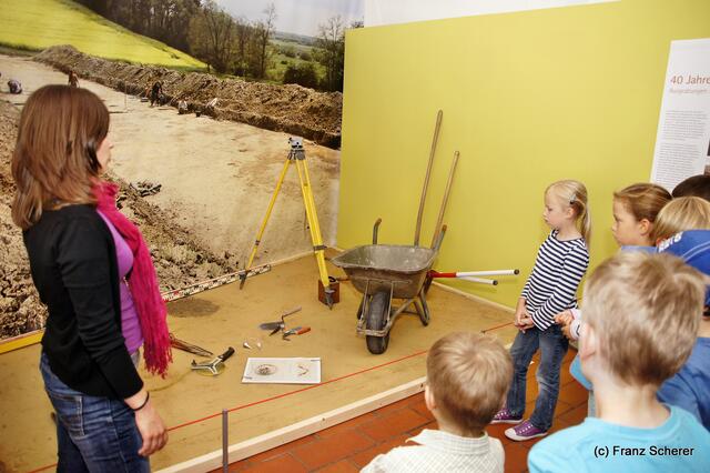 Botschaft an die Zukunft. Kinderprogramm zur Sonderausstellung "Ausgegraben - Archäologie am Friedberger Lechrain" im Museum im Friedberger Wittelbacher Schloss. MAriella Hosp hat aufmerksame Zuhörer