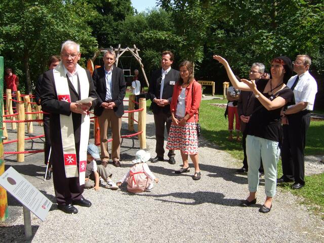 Pfarrer Georg Egger spendet den Segen für den neu eröffneten Therapie- und Sinnesgarten. V. li. Bürgermeister Hansjörg Durz, Diözesangeschäftsführer Alexander Pereira, Landschaftsarchitektin Marion Hemmers. Kommunikationsassistentin Alexandra Richter-Uhl übersetzt in Deutsche Gebärdensprache.