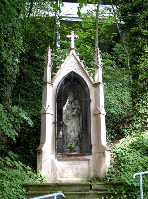 Durch den Mendener Bildhauer Caspar Grahs wurde 1907 dieser Marienbildstock geschaffen. Es zeigt die Madonna mit Christuskind in neugotischem Heiligenhäuschen.