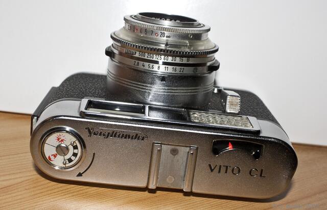 Von links: Rückspulknopf mit Filmerinnerungseinrichtung (Tageslicht, Kunstlicht, s/w), Blitzschuh (locker), Nachführbelichtungsmesser.