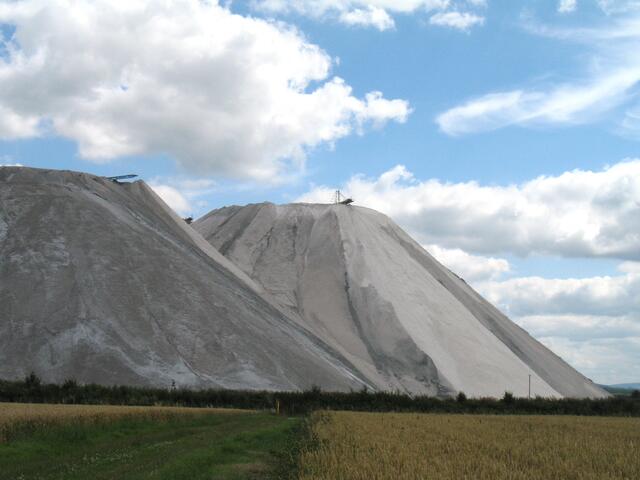 Hoch ragen sie in den blauen Himmel. Zum Teil wird der Abraum wieder zum Verfüllen der Hallen benutzt. Irgendwann werden die Hänge begrünt werden, wie es teilweise schon geschehen ist.