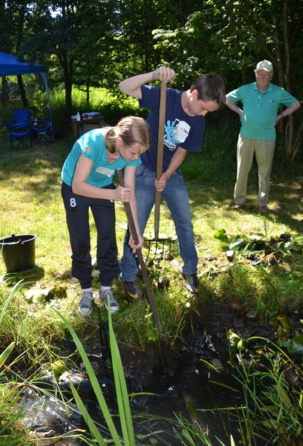 Annika holt mit Jan Niklas die Steine aus dem Teich.