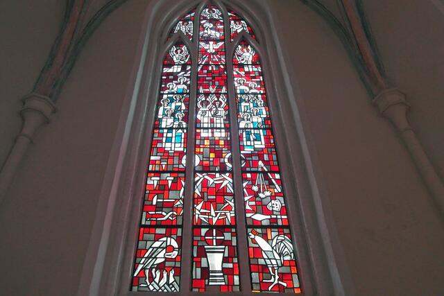 Im mittleren Kirchenfenster geht es um das Thema "Liebe" mit dem feurigen Rot als Hintergrundfarbe. Im unteren Teil des Fensters sind ein Abendmahlskelch, Marterwerkzeuge der Passion, ein Pelikan, der seine Jungen mit seinem Herzblut füttert, und ein Hahn, der an den Verrat erinnert, zu erkennen.
