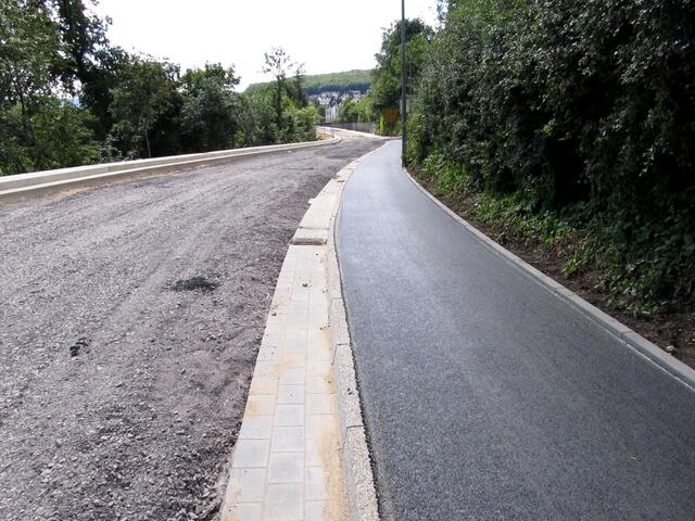 Eine neue Fahrradrennstrecke? Eine total glatte Teerfläche auf dem Bürgersteig. Ich denke, es wird ein Fahrrad-/Fußweg.