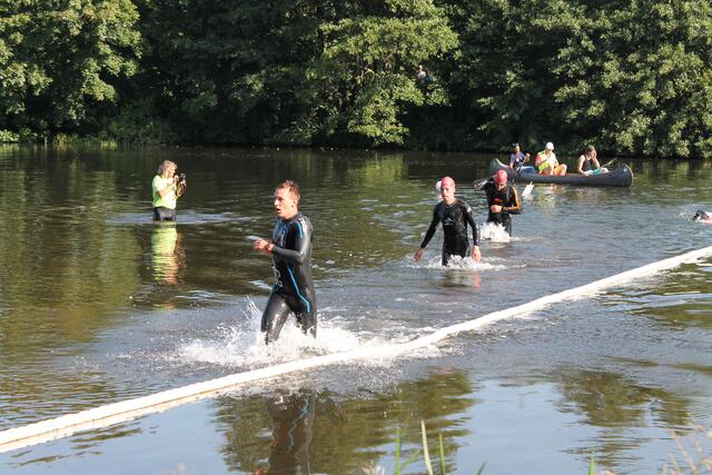 Die schnellsten Schwimmer der ersten Startgruppe laufen aus dem Wasser der Aller.