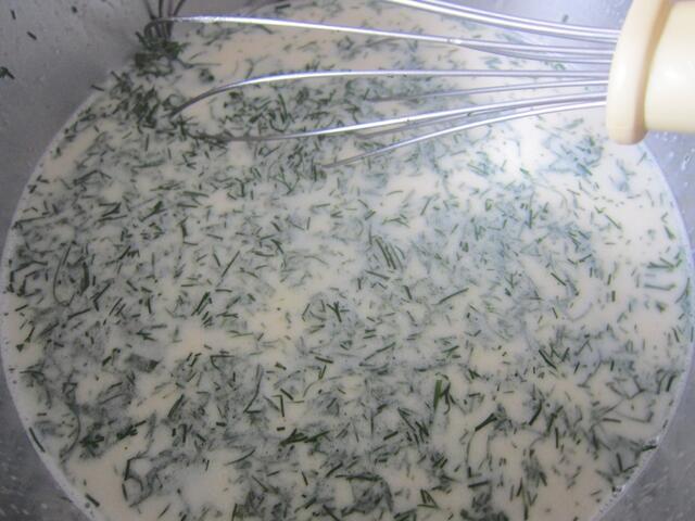 Wenn sich die Brühe in der Milch aufgelöst hat, Kräuter und Gurken hinzugeben und gut verrühren