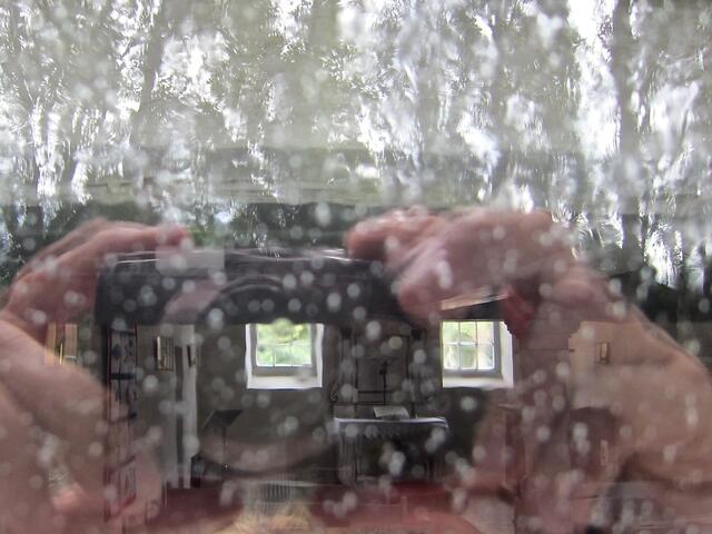 Durch das regennasse Fenster in die Kapelle fotografiert