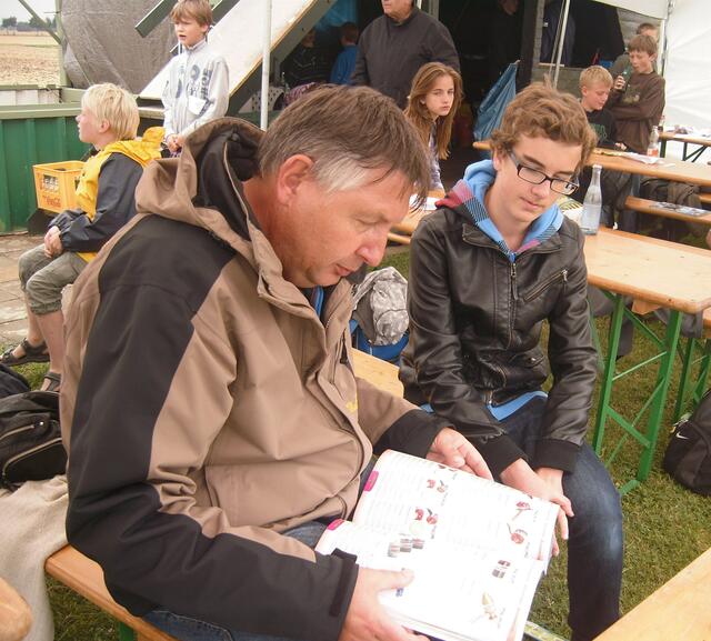 Carsten Wagener stöbert mit Dennis im Katalog