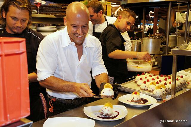 Edel & Weiß - Gourmetabend in der Sterndl'Alm auf dem Augsburger Herbstplärrer - Gute Laune in der Sterndl'Alm-Küche. Alm-Chef Christian Balletshofer beim Anrichten seiner Dessert-Kreation "Chill Berry Tart"
