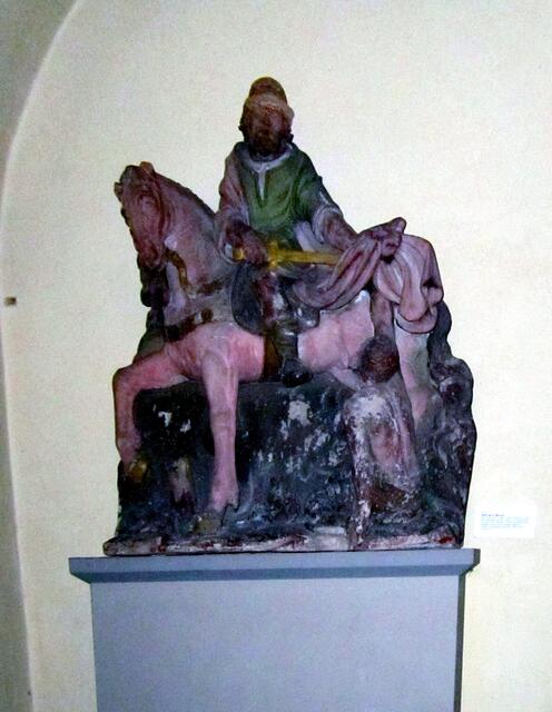 Das Relief des hl. St. Martin stand ursprünglich in der Nische über dem Hauptportal. Aus konservatorischen Gründen wurde es 1988 in der Kirche aufgestellt und außen eine Replik angebracht.
