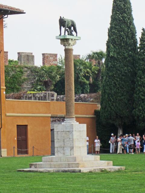 Pisa - Toscana - Italien.
Piazza dei Miracoli                                                                Die Säule „Der Wolf von Rom“ steht auf dem Rasen 
Piazza dei Miracoli - "Platz der Wunder",
zwischen dem Glockenturm und der Kathedrale. 
(1926)
Romulus und Remus sollen im Jahre 753 v. Chr. die Gründer der Stadt Rom gewesen sein.