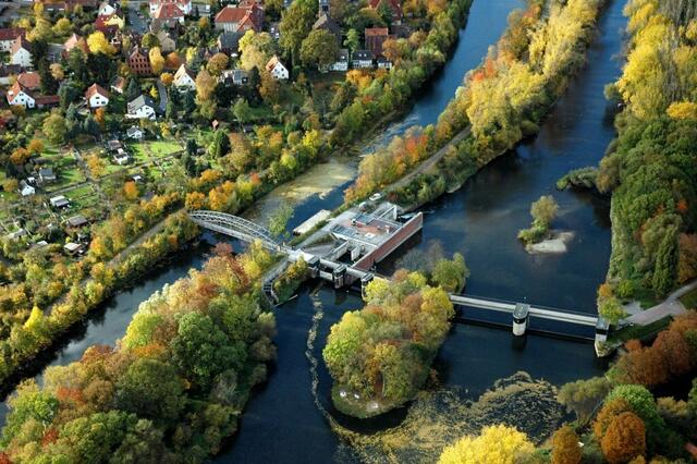 Hannover Limmer/Herrenhausen: Fehlplanung! Links unter der Bogenbrücke hindurch ist die Zufahrt zum Stichkanal und zur Umsetzmöglichkeit per Ufertreppe in die Leine nach rechts. Besser wäre rechts neben der Bogenbrücke der Fischpass ein Kombipass geworden. Rechts geht es zur historischen Holzschleuse, aufwändig zur EXPO 2000 mit EU-Steuergeldern saniert, inzwischen versandet und für Kanuwanderbetrieb auch unpraktisch. Rechts daneben bei der Wasserkunst wäre ein Borsten-Kombi-Kanu/Fischpass sinnvoll !! | Foto: Hannover