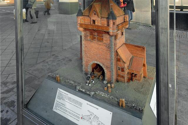 In der Innenstadt werden wieder die Modelle von zehn historischen Gebäuden in Vitrinen gezeigt, hier in der Holstenstraße das Modell des inneren Holstentores (vermutlich 1376 errichtet, 1794 abgebrochen).