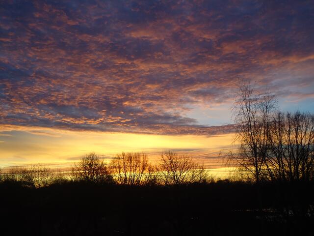 Langsam ändert der Himmel die Farbe von rot nach golden und die Wolken kräuseln sich vor freudiger Erwartung des kommenden Sonnenaufganges